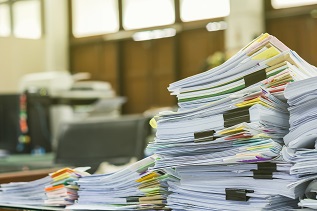 Stapel von Akten und Papieren sinnbildlich für hohe Bürokratie